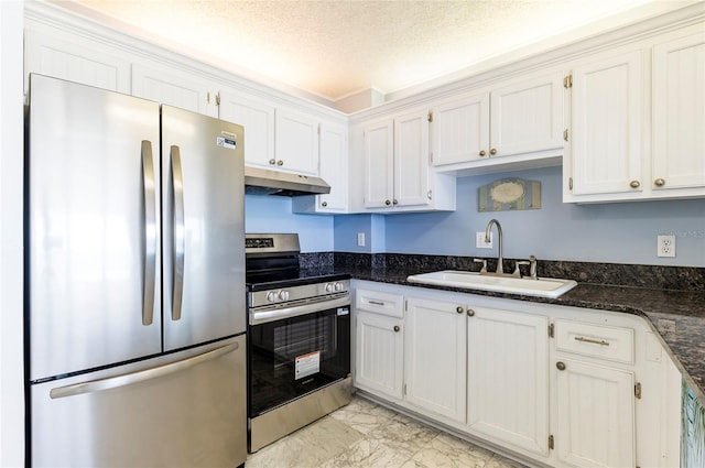1270 Gulf Blvd Unit 1605, Clearwater Beach, FL 33767 - kitchen featuring stainless steel appliances, under cabinet range hood, light marble finish floors, a textured ceiling, and dark stone counters