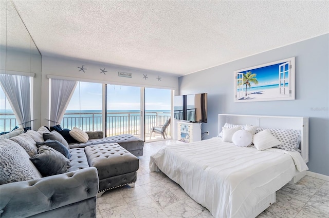 1270 Gulf Blvd Unit 1605, Clearwater Beach, FL 33767 - bedroom featuring light marble finish floors, access to outside, a water view, and a textured ceiling