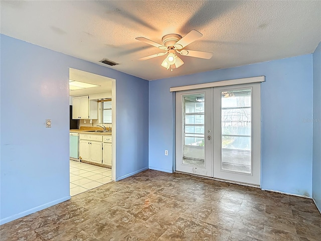 6250 7th Ave, New Port Richey, FL 34653 - unfurnished room with french doors, ceiling fan, a textured ceiling, and light stone finish floors