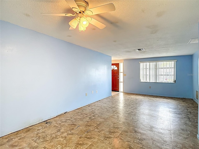 6250 7th Ave, New Port Richey, FL 34653 - empty room with a textured ceiling, ceiling fan, and stone finish flooring