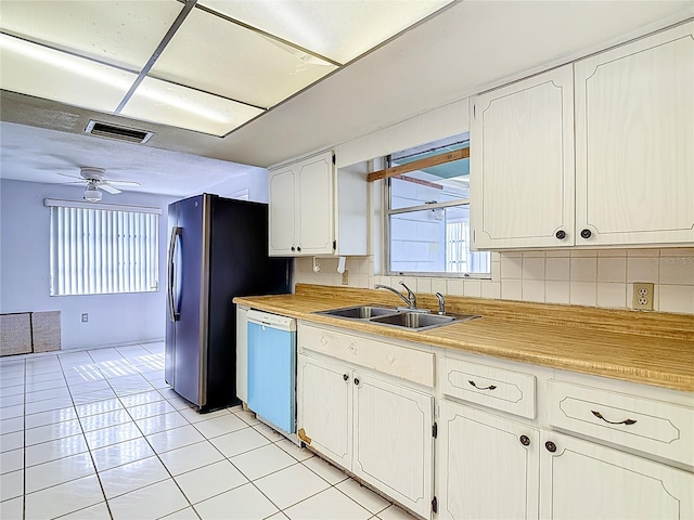 6250 7th Ave, New Port Richey, FL 34653 - kitchen featuring white dishwasher, light tile patterned floors, light countertops, and healthy amount of natural light