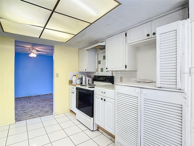 6250 7th Ave, New Port Richey, FL 34653 - kitchen featuring electric range, a ceiling fan, light countertops, light tile patterned floors, and white cabinetry