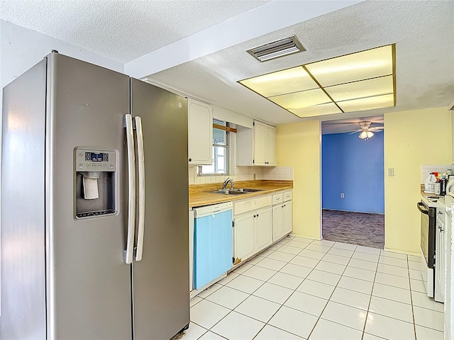 6250 7th Ave, New Port Richey, FL 34653 - kitchen with white appliances, a ceiling fan, light countertops, a textured ceiling, and light tile patterned floors