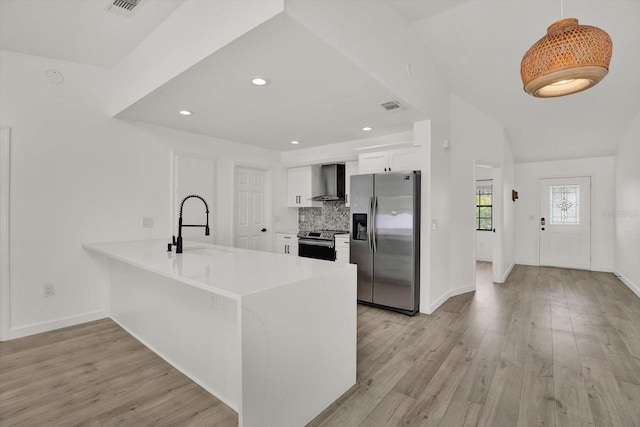 10319 Alberta Ct, New Port Richey, FL 34654 - kitchen with appliances with stainless steel finishes, wall chimney exhaust hood, a peninsula, white cabinets, and light wood-style floors