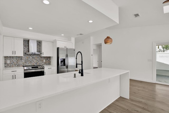10319 Alberta Ct, New Port Richey, FL 34654 - kitchen featuring wall chimney range hood, appliances with stainless steel finishes, tasteful backsplash, recessed lighting, and white cabinets
