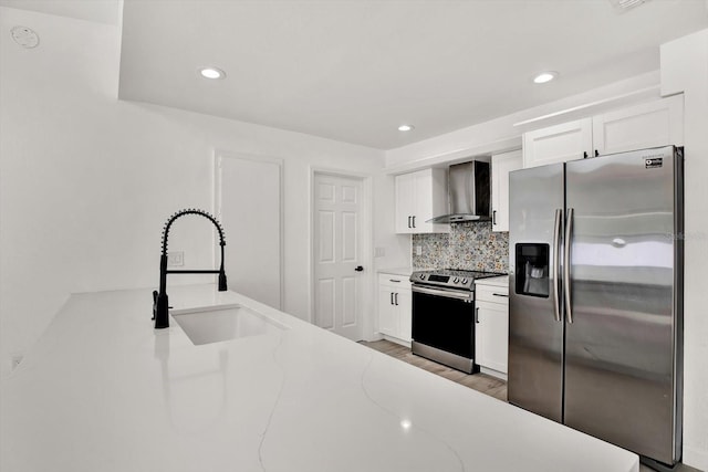 10319 Alberta Ct, New Port Richey, FL 34654 - kitchen with appliances with stainless steel finishes, wall chimney exhaust hood, white cabinetry, backsplash, and light wood-type flooring