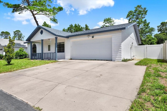 10319 Alberta Ct, New Port Richey, FL 34654 - ranch-style house with covered porch, an attached garage, driveway, and a gate