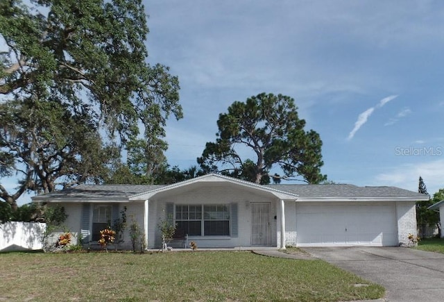 7534 Betula Dr, New Port Richey, FL 34653 - ranch-style home with an attached garage, brick siding, concrete driveway, and a front lawn