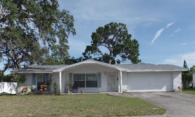 7534 Betula Dr, New Port Richey, FL 34653 - ranch-style house featuring brick siding, a garage, a front lawn, and driveway