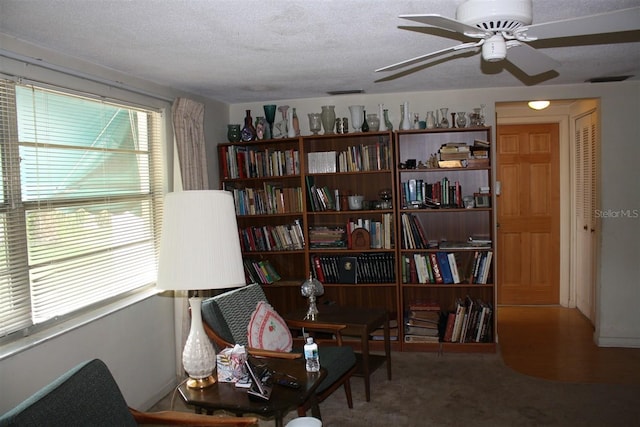 7534 Betula Dr, New Port Richey, FL 34653 - sitting room with a ceiling fan, a textured ceiling, and carpet flooring