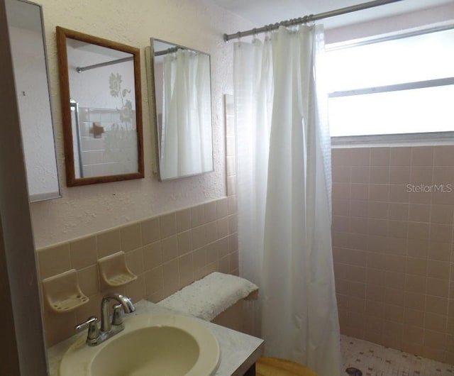7534 Betula Dr, New Port Richey, FL 34653 - full bath featuring a tile shower, tile walls, vanity, and a textured wall