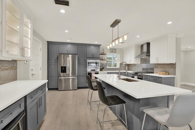 11890 Walker Ave, Seminole, FL 33772 - kitchen featuring stainless steel appliances, wall chimney range hood, a breakfast bar area, decorative backsplash, and recessed lighting
