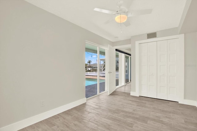 11890 Walker Ave, Seminole, FL 33772 - unfurnished bedroom featuring wood finished floors, access to exterior, a ceiling fan, and a closet