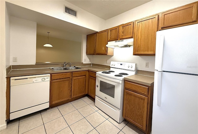 6448 Cypressdale Dr Unit 101, Riverview, FL 33578 - kitchen with white appliances, under cabinet range hood, brown cabinetry, light tile patterned flooring, and decorative light fixtures