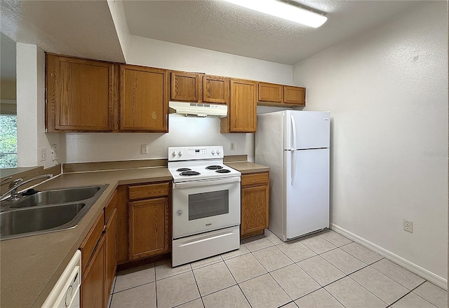 6448 Cypressdale Dr Unit 101, Riverview, FL 33578 - kitchen with white appliances, under cabinet range hood, brown cabinetry, light tile patterned floors, and a textured ceiling