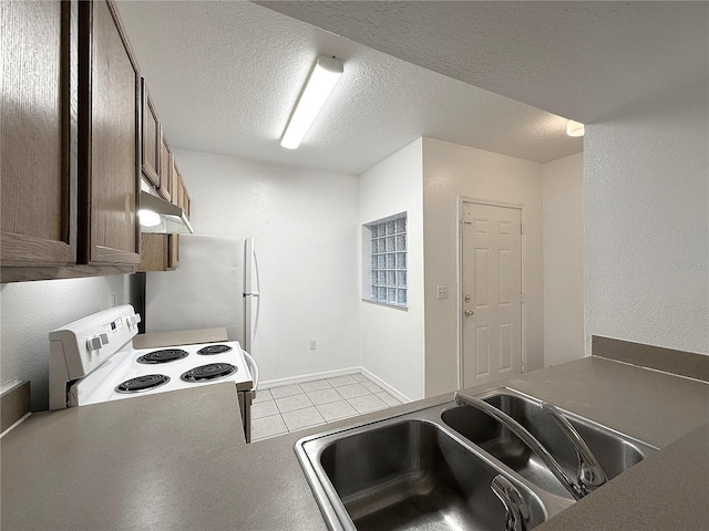 6448 Cypressdale Dr Unit 101, Riverview, FL 33578 - kitchen featuring white appliances, a textured ceiling, light tile patterned floors, and under cabinet range hood
