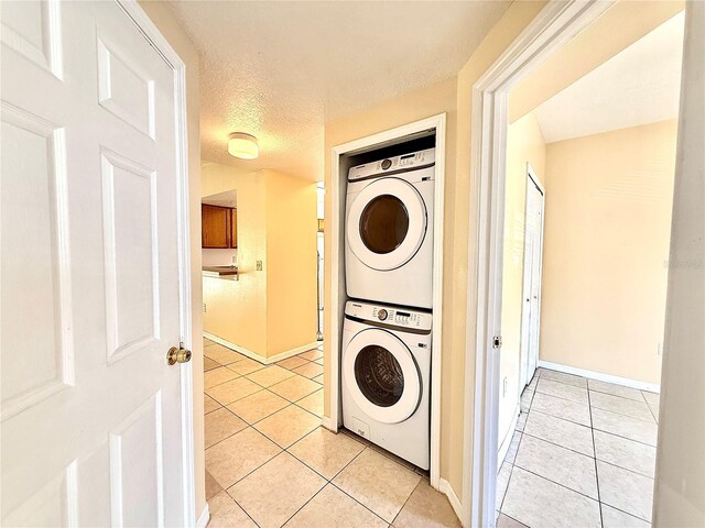 6448 Cypressdale Dr Unit 101, Riverview, FL 33578 - laundry area featuring estacked washer and dryer, light tile patterned flooring, and a textured ceiling