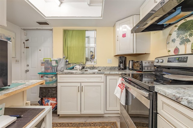 6015 Arlene Way, Bradenton, FL 34207 - kitchen with electric stove, under cabinet range hood, white cabinets, and light stone countertops
