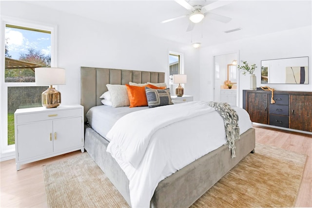 13344 Sorrento Dr, Largo, FL 33774 - bedroom featuring light wood finished floors, connected bathroom, and ceiling fan