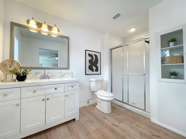 13344 Sorrento Dr, Largo, FL 33774 - full bathroom with vanity, wood finished floors, a stall shower, and a ceiling fan