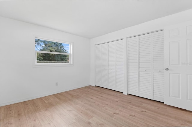 13344 Sorrento Dr, Largo, FL 33774 - unfurnished bedroom featuring multiple closets and light wood-style flooring