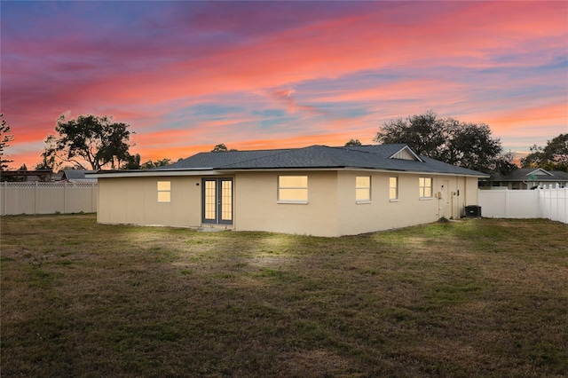 13344 Sorrento Dr, Largo, FL 33774 - back of house at dusk with french doors and a fenced backyard