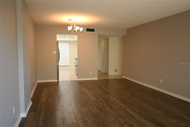 2800 Cove Cay Dr Unit 5D, Clearwater, FL 33760 - spare room featuring a chandelier, wood-type flooring, and a textured ceiling