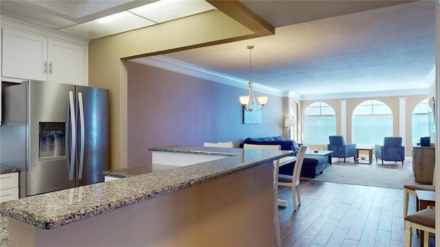4950 Gulf Blvd Unit 1006, St Pete Beach, FL 33706 - kitchen with stainless steel fridge with ice dispenser, crown molding, open floor plan, dark stone countertops, and dark wood-style flooring