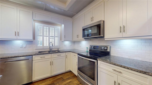 4950 Gulf Blvd Unit 1006, St Pete Beach, FL 33706 - kitchen featuring appliances with stainless steel finishes, dark wood-style floors, dark stone counters, and white cabinets
