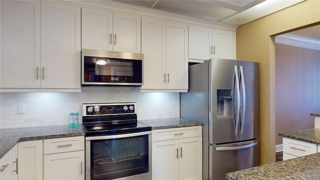 4950 Gulf Blvd Unit 1006, St Pete Beach, FL 33706 - kitchen featuring stainless steel appliances, white cabinets, dark stone counters, and decorative backsplash