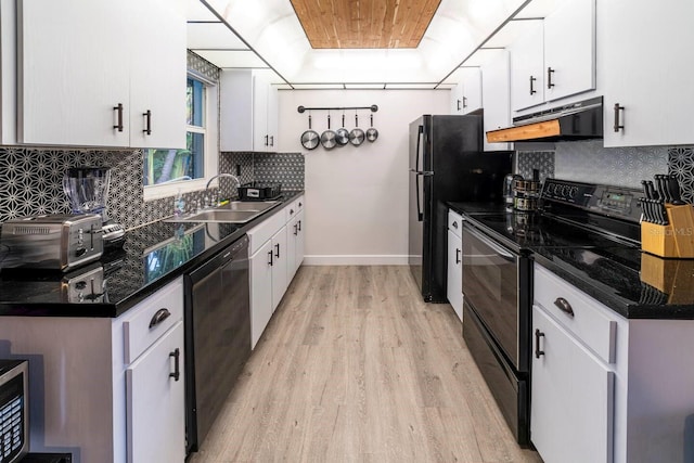 574 6th Ave SE, Largo, FL 33771 - kitchen featuring black appliances, under cabinet range hood, light wood-style flooring, and white cabinets