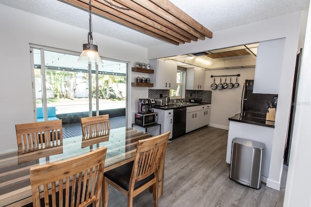 574 6th Ave SE, Largo, FL 33771 - kitchen with black dishwasher, dark countertops, fridge, and white cabinets