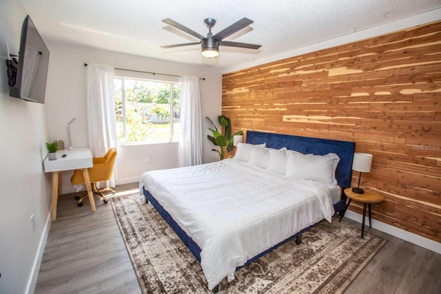 574 6th Ave SE, Largo, FL 33771 - bedroom featuring wooden walls, wood finished floors, and a ceiling fan
