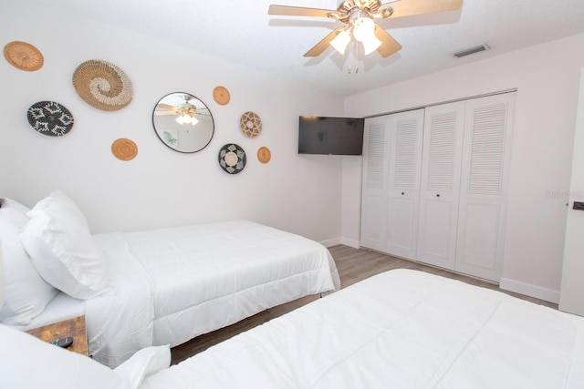 574 6th Ave SE, Largo, FL 33771 - bedroom with wood finished floors, a ceiling fan, and a closet