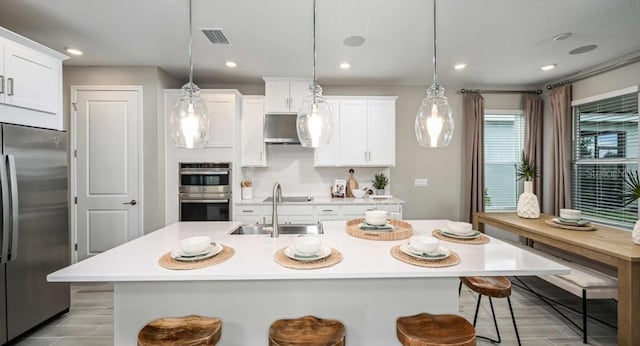 2128 Babbling Brook Blvd, Auburndale, FL 33823 - kitchen featuring appliances with stainless steel finishes, light countertops, a breakfast bar, white cabinets, and recessed lighting