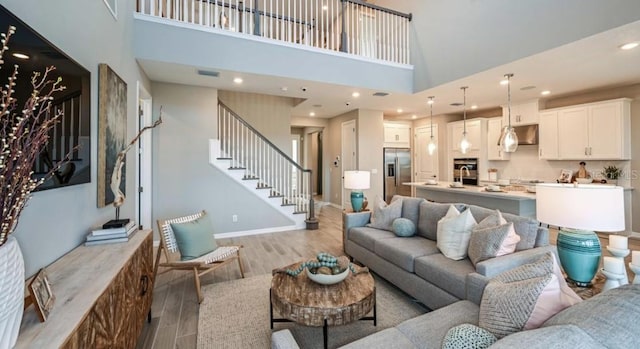 2128 Babbling Brook Blvd, Auburndale, FL 33823 - living area featuring light wood-style flooring, a towering ceiling, stairway, and recessed lighting