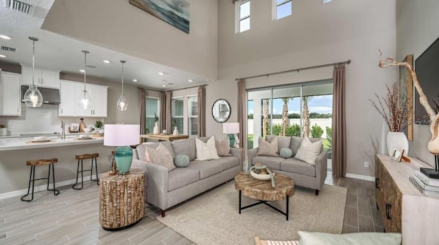 2128 Babbling Brook Blvd, Auburndale, FL 33823 - living area featuring wood finish floors, recessed lighting, a towering ceiling, and a water view