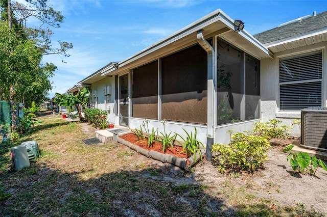 1150 Jade E Ln, Kissimmee, FL 34744 - view of side of property featuring a sunroom and stucco siding