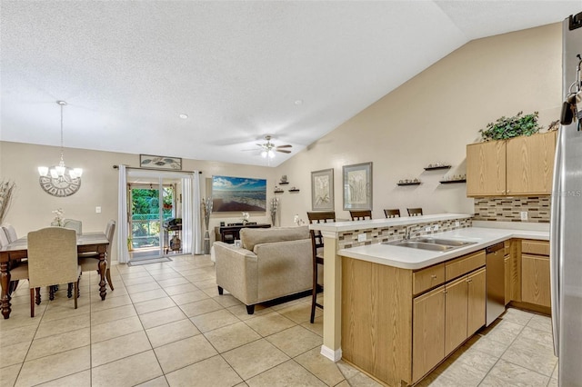 1150 Jade E Ln, Kissimmee, FL 34744 - kitchen featuring lofted ceiling, a peninsula, stainless steel appliances, light countertops, and decorative backsplash