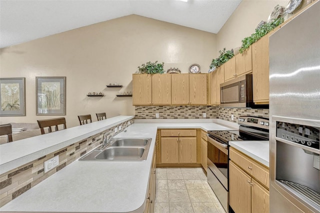 1150 Jade E Ln, Kissimmee, FL 34744 - kitchen with appliances with stainless steel finishes, light brown cabinets, lofted ceiling, backsplash, and a peninsula
