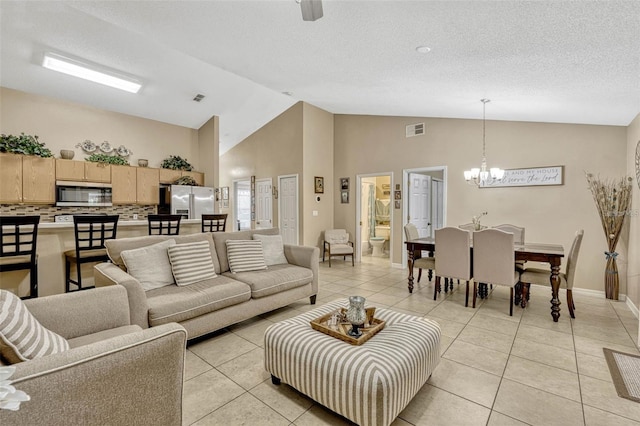 1150 Jade E Ln, Kissimmee, FL 34744 - living room with a chandelier, light tile patterned flooring, high vaulted ceiling, and a textured ceiling