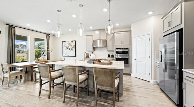 2422 Babbling Brook Blvd, Auburndale, FL 33823 - kitchen with appliances with stainless steel finishes, under cabinet range hood, light wood-style floors, recessed lighting, and light countertops