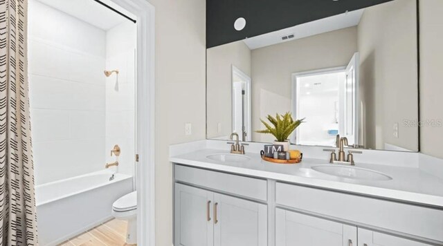 2422 Babbling Brook Blvd, Auburndale, FL 33823 - bathroom featuring double vanity, shower / bath combo with shower curtain, and wood finished floors