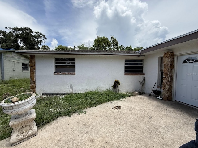 13097 120th St, Largo, FL 33778 - view of home's exterior featuring stucco siding and a patio