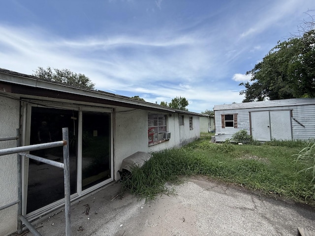 13097 120th St, Largo, FL 33778 - view of home's exterior featuring a storage shed and stucco siding