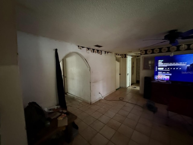 13097 120th St, Largo, FL 33778 - unfurnished living room with a textured ceiling, tile patterned flooring, and ceiling fan