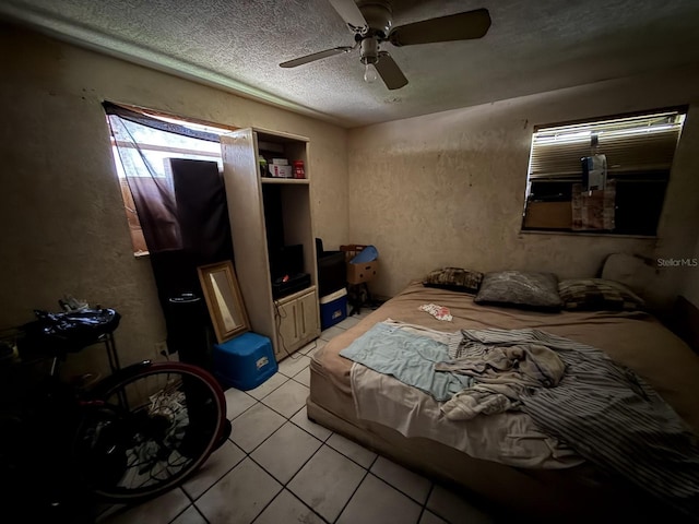 13097 120th St, Largo, FL 33778 - bedroom featuring light tile patterned flooring, a textured ceiling, a ceiling fan, and a textured wall