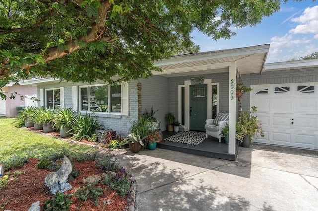 2009 Woodward Ave, Dunedin, FL 34698 - single story home featuring brick siding, an attached garage, concrete driveway, and a porch
