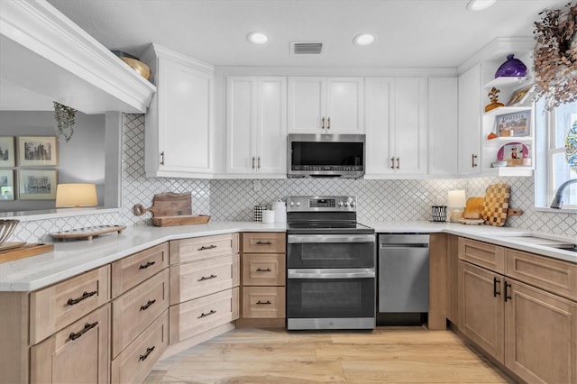 2009 Woodward Ave, Dunedin, FL 34698 - kitchen with stainless steel appliances, open shelves, backsplash, white cabinetry, and recessed lighting