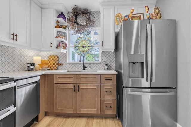 2009 Woodward Ave, Dunedin, FL 34698 - kitchen featuring appliances with stainless steel finishes, light countertops, decorative backsplash, and white cabinetry